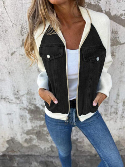 Person wearing a black and white denim jacket with a neutral background