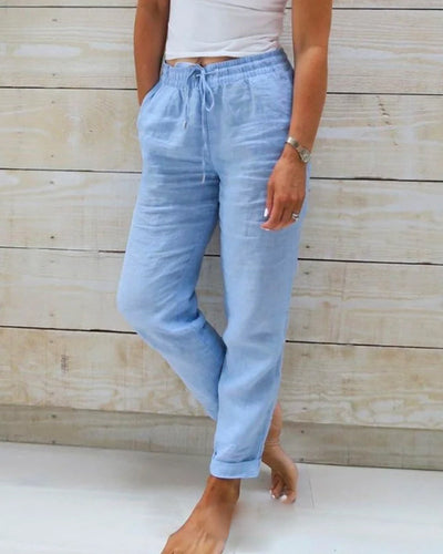 Light blue jeans worn by a person against a wooden background
