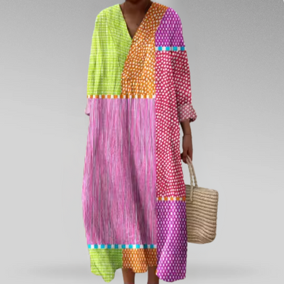 Colorful patchwork dress worn by a person on a gray background